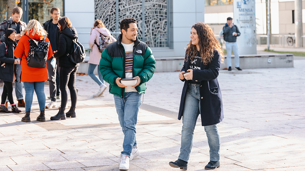 Studierende auf dem Weg zur Mensa mit wiederverwendbaren Boxen für ihr Essen (c) Hannah Theile Uni Magdeburg