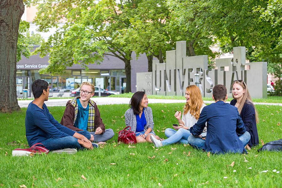 Studierende sitzen vor der Uniporta im Gras (c) Stefan Berger Uni Magdeburg