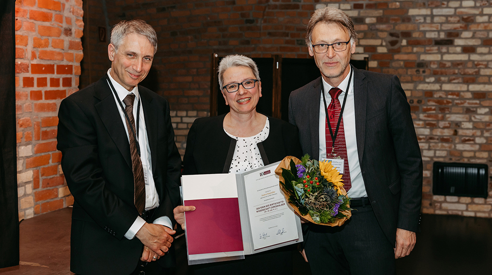 Prof. Dr. Abdolkarim Sadrieh, Prof. Dr. Gudrun Kiesmüller mit der Urkunde zur Ehrendoktorwürde und der Rektor der Universität Magdeburg, Prof. Dr. Jens Strackeljan (c) Jana Dünnhaupt Uni Magdeburg