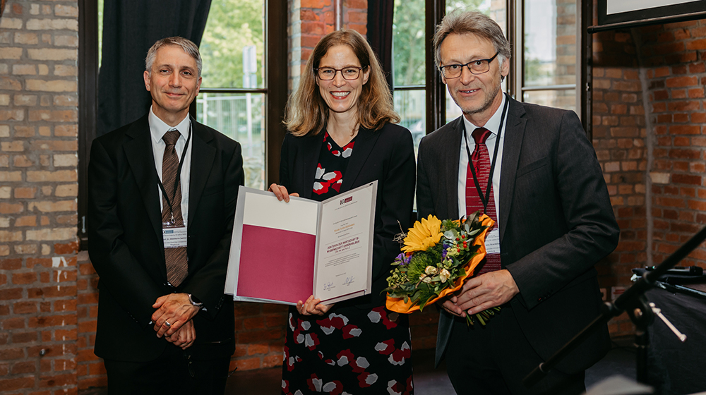 Prof. Dr. Abdolkarim Sadrieh, Prof. Dr. Nicola Fuchs-Schündeln mit der Urkunde zur Ehrendoktorwürde und der Rektor der Universität Magdeburg, Prof. Dr. Jens Strackeljan (c) Jana Dünnhaupt Uni Magdeburg