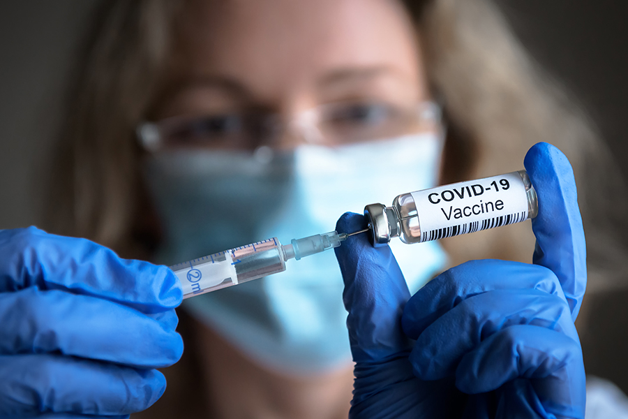 Wissenschaftlerin hält Covid-19-Impfstoff in der Hand (c) shutterstock_Viacheslav Lopatin