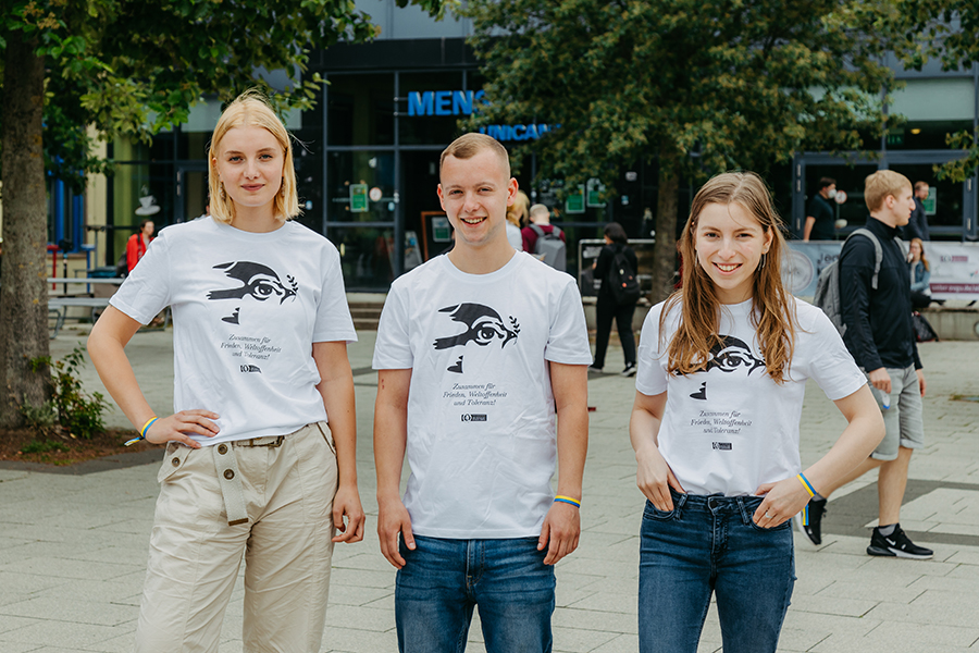 3 Studierende auf dem Mensavorplatz der Uni Magdeburg mit dem Spendenshirt für die Ukraine (c) Jana Dünnhaupt Uni Magdeburg