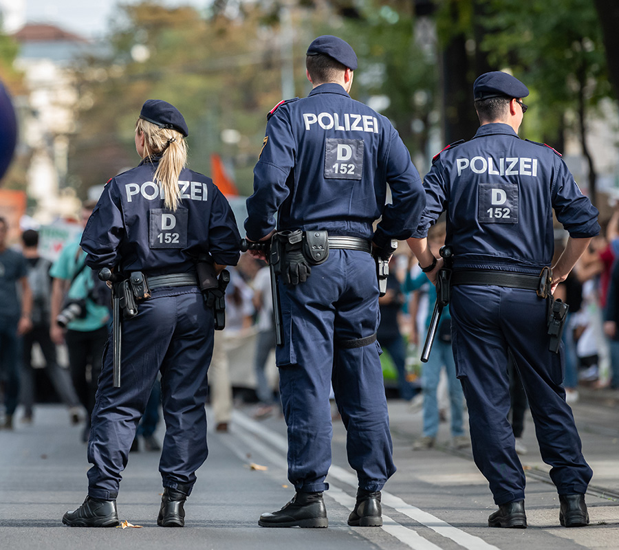 Drei Polizisten von hinten zu sehen bei einem Einsatz (c) Shutterstock Stefan Rotter