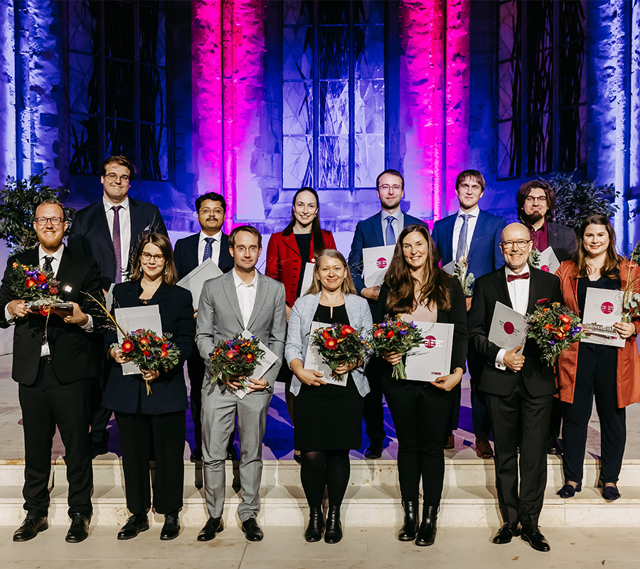  Wissenschaftlerinnen und Wissenschaftler der Uni Magdeburg stehn mit Bumen und Auszeichungen auf einer Treppe. (c) Foto: Jana Dünnhaupt