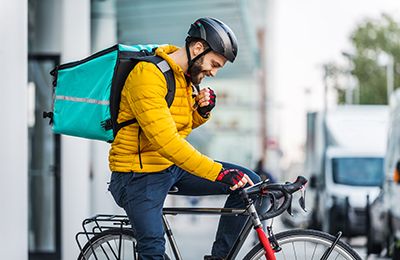 Lebensmittelzulieferdienst, Fahrer, der den Kunden mit dem Fahrrad Lebensmittel liefert - Konzepte über Transport, Lieferung von Nahrungsmitteln und Technologie (c) oneinchpunch/shutterstock