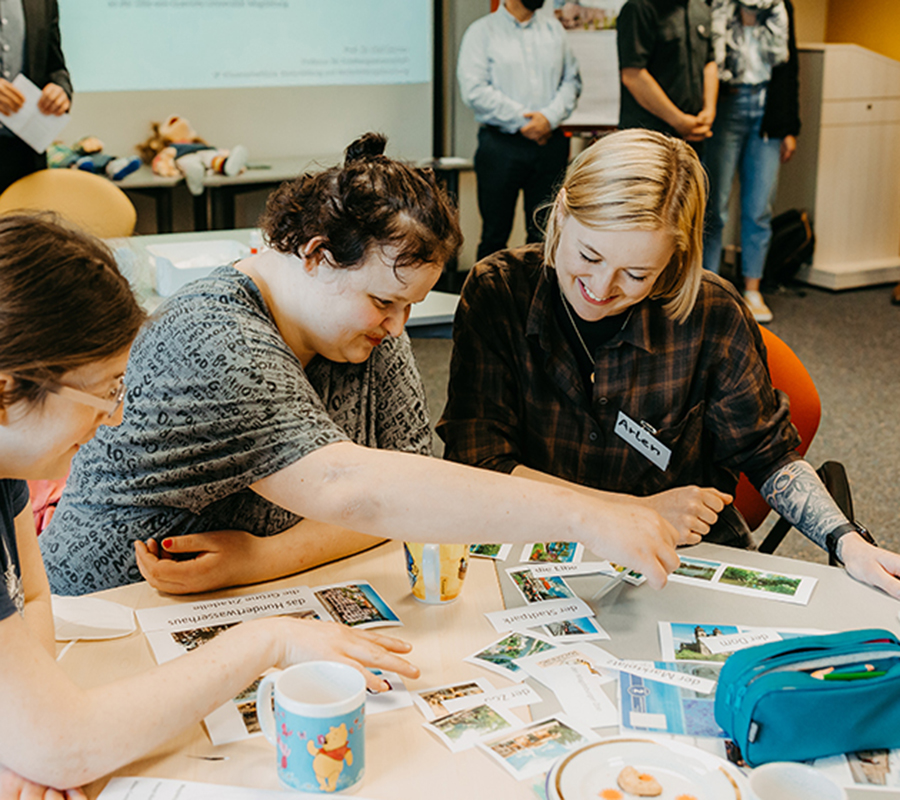 Zwei Mitarbeiterinnen einer Behindertenwerkstatt und eine Studentin lernen gemeinsam im Rahmen der Werkstatt-Uni (Foto: Jana Dünnhaupt/Uni Magdeburg)